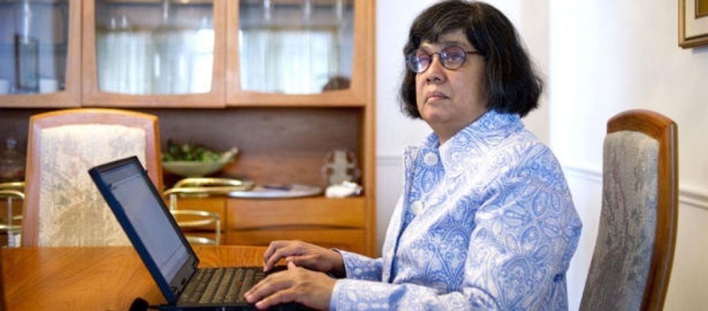Donna Jodhan sits typing on a laptop in a home office table.