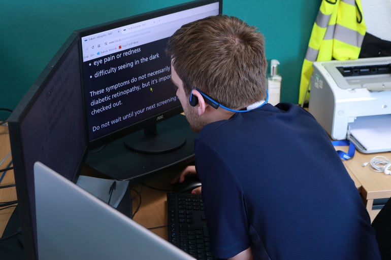 Work experience student Sam is reading with SuperNova Magnifier on a PC in the Dolphin office