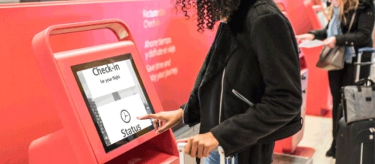 Image shows lady using a SuperNova Kiosk at an airport