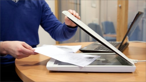 Image shows person scanning a paper document