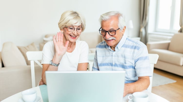 Older couple smile at laptop screen while on video call