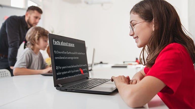 Student using SuperNova Education Kit in class, another student and a teacher are in the background