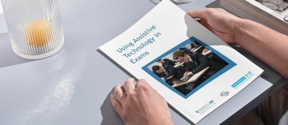 Hands holding a printed out version of the Guide to Using AT in Exams