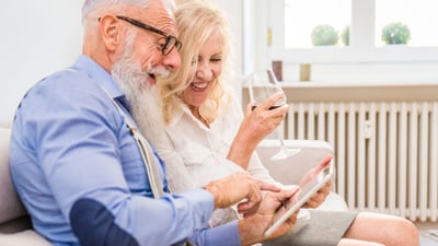 laughing couple looking at screen on computer tablet