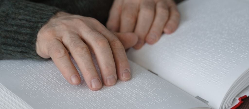 hands shown as they read braille book